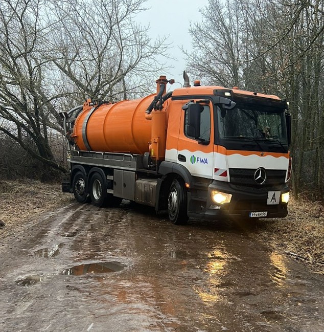 Fahrzeug der Grubenabfuhr auf vereistem Weg